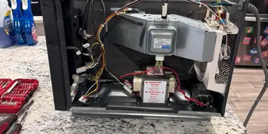 Real microwave repair with the cabinet safely opened for diagnosis