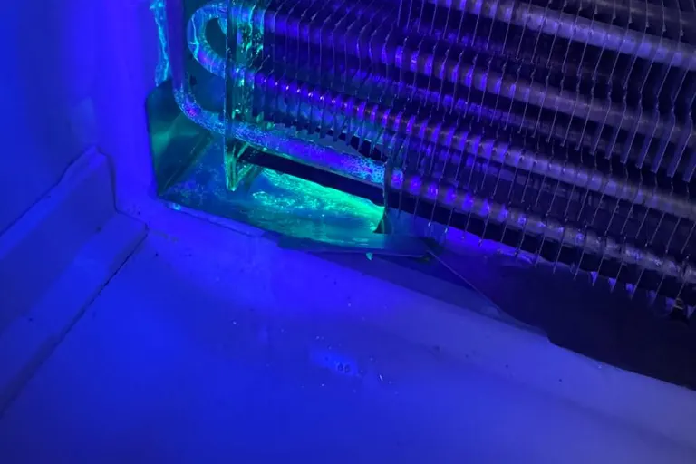UV dye visible during refrigerator evaporator leak inspection