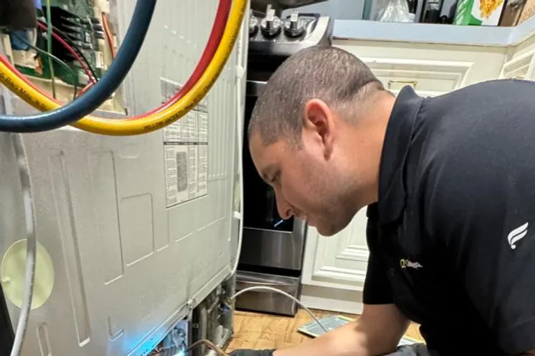 Quality Repairs technician performing sealed-system service on a refrigerator